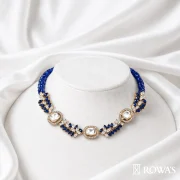 Aurora Majestic Necklace with Uncut Diamonds Gross wt – 28.36 gms Gold wt – 23.168gms Polki – 1.62cts Diamonds – 7.38 cts Blue sapphire – 16.34cts Inspired by the enchanting beauty of a moonlit night, this necklace features a stunning arrangement of blue sapphires and diamonds. The delicate interplay of light and dark evokes the serenity and mystery of midnight, making it a captivating addition to any jewelry collection.